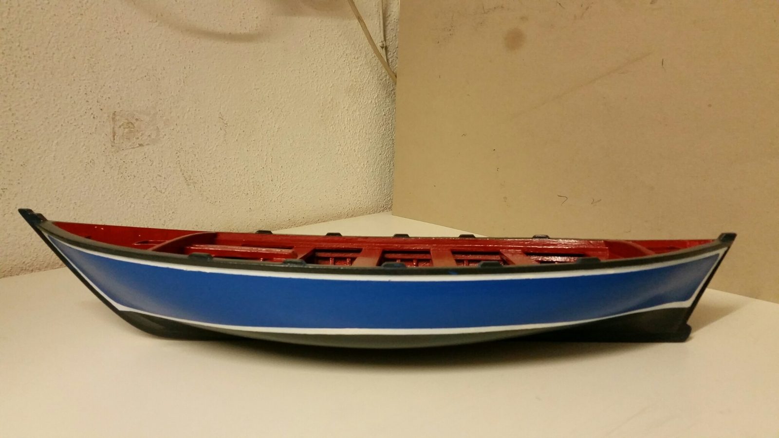 Modelo de catraia pintada de azul e vermelho